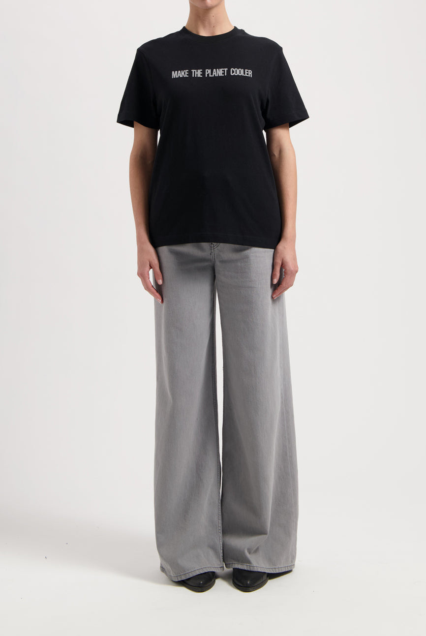 Sustainable MUD Jeans in dark brown, crafted with ethical materials, shown in a slim fit, paired with a casual white tee.