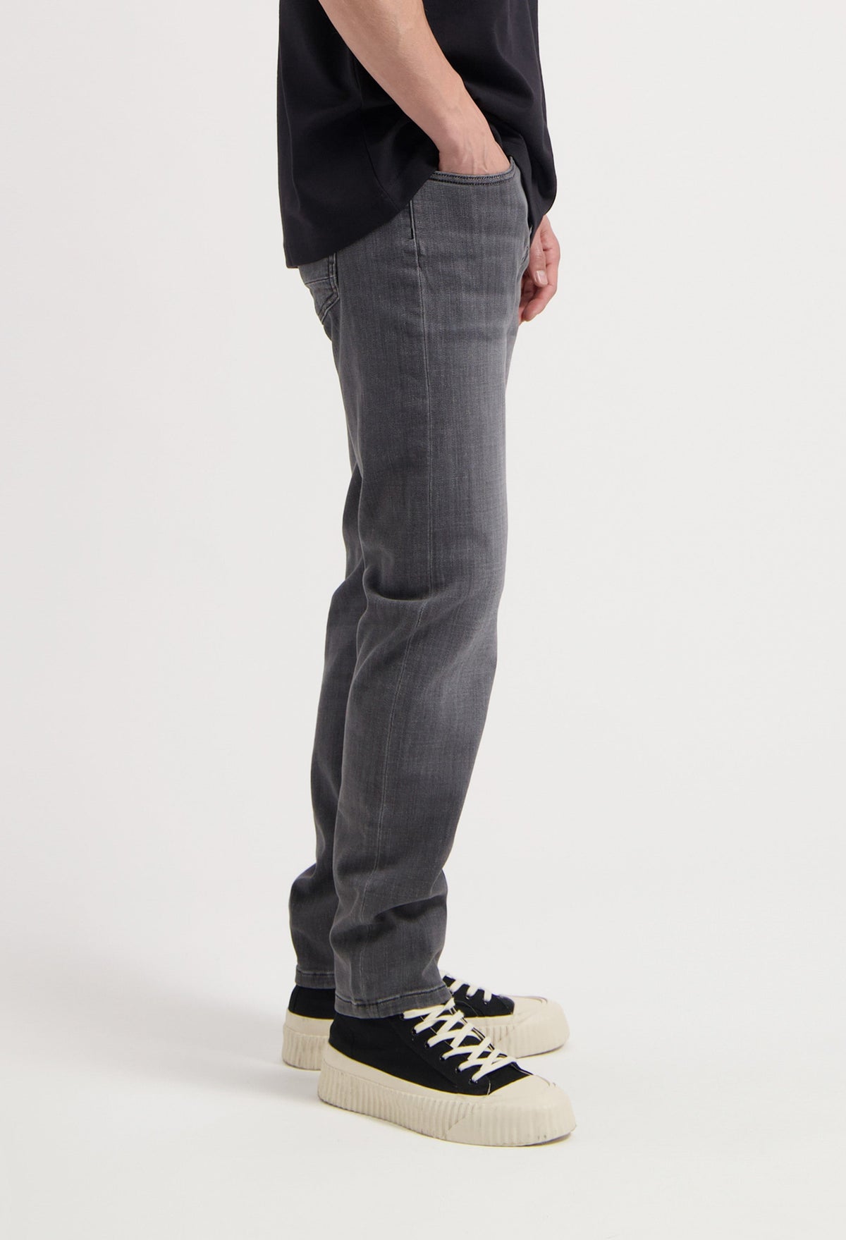 Sustainable MUD Jeans in light blue denim, crafted ethically, featuring a classic fit, paired with a white top.