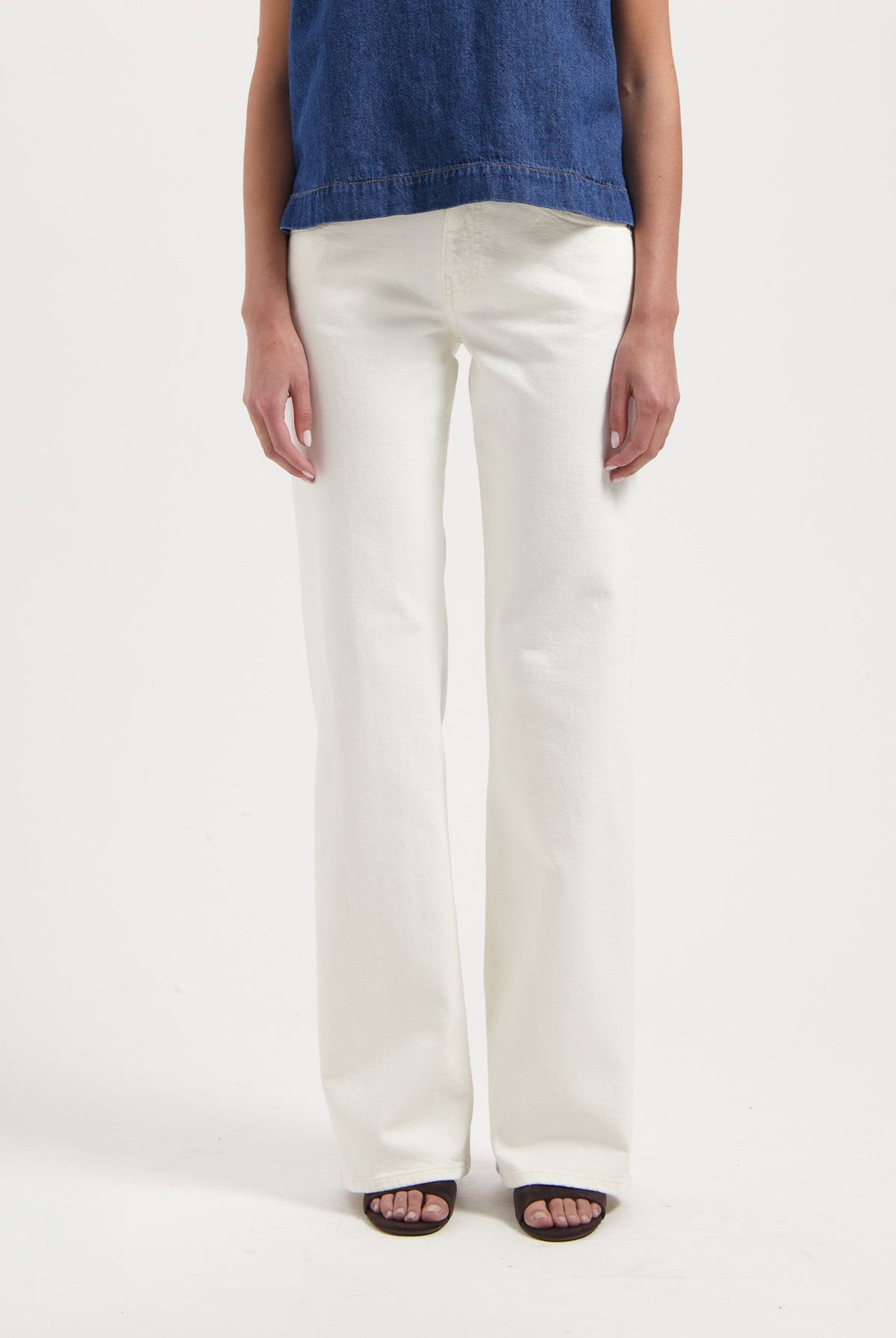 Wide-leg white jeans styled with an indigo denim sleeveless top, showcasing a minimalistic and modern fashion ensemble.