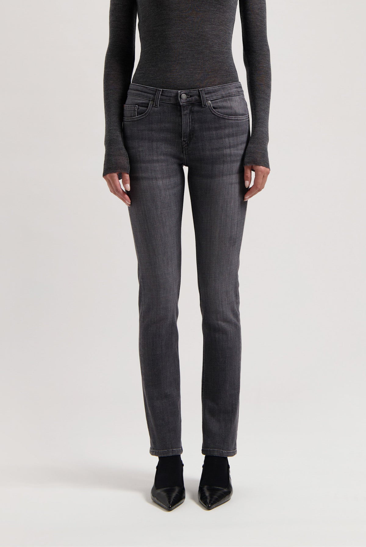 Slim-fit dark gray denim jeans styled with long-sleeve charcoal top and black pointed shoes, showcasing modern casualwear.
