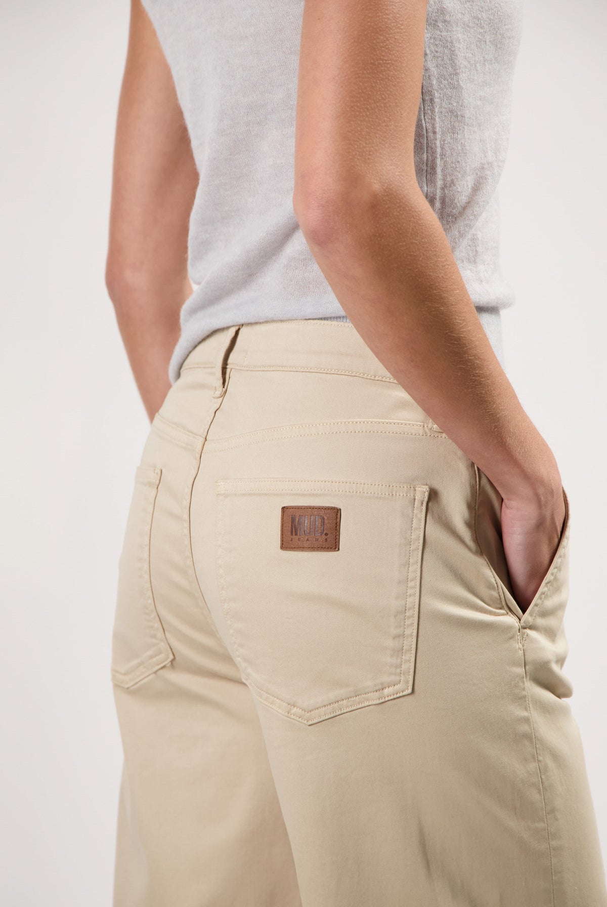 Beige MUD Jeans crafted from sustainable materials, showcasing a rear view of the relaxed-fit, casual trousers with logo detail.