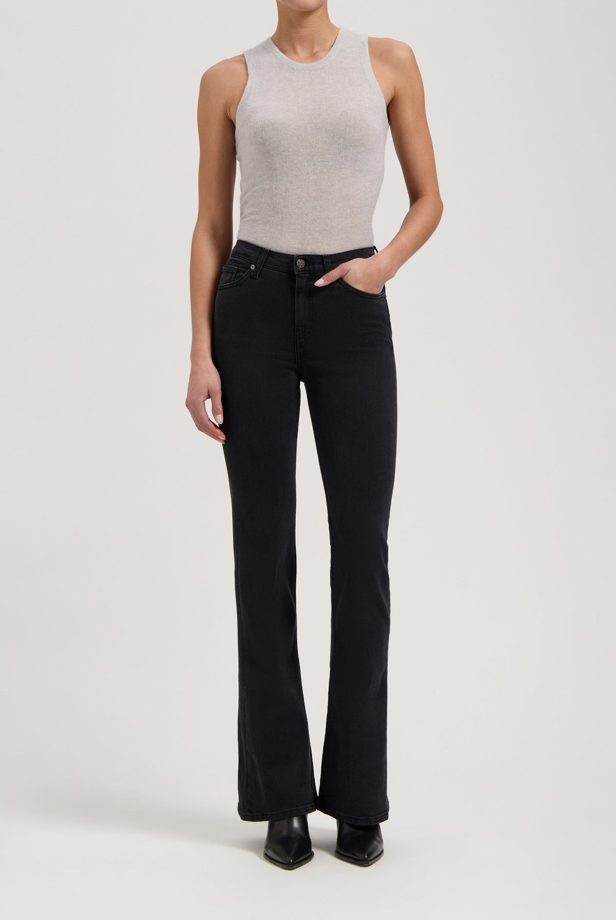 Ribbed gray sleeveless top paired with black high-waisted bootcut jeans and black ankle boots.