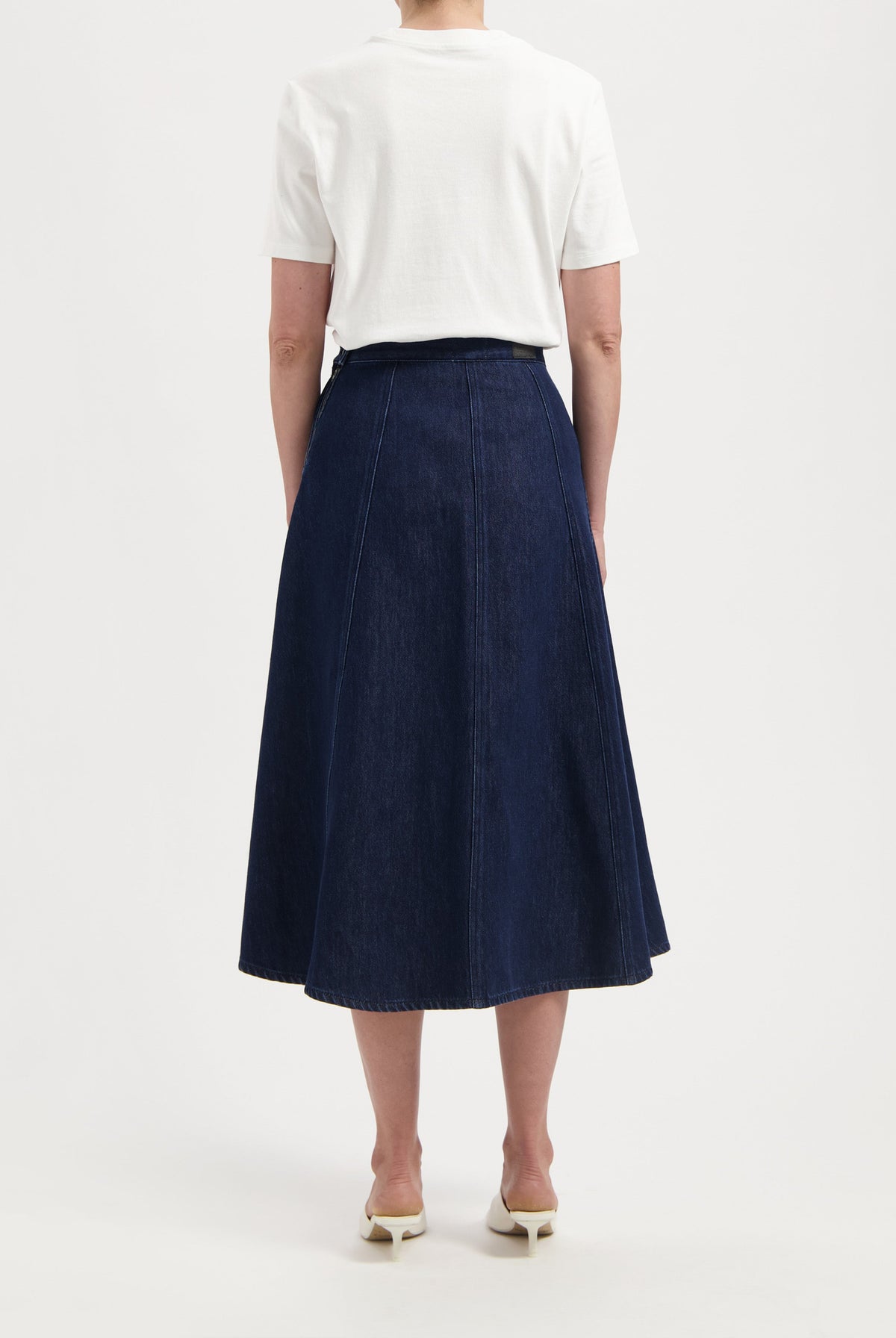 A-line dark blue denim skirt paired with a white short-sleeve top, showcasing a casual, elegant look from the back.